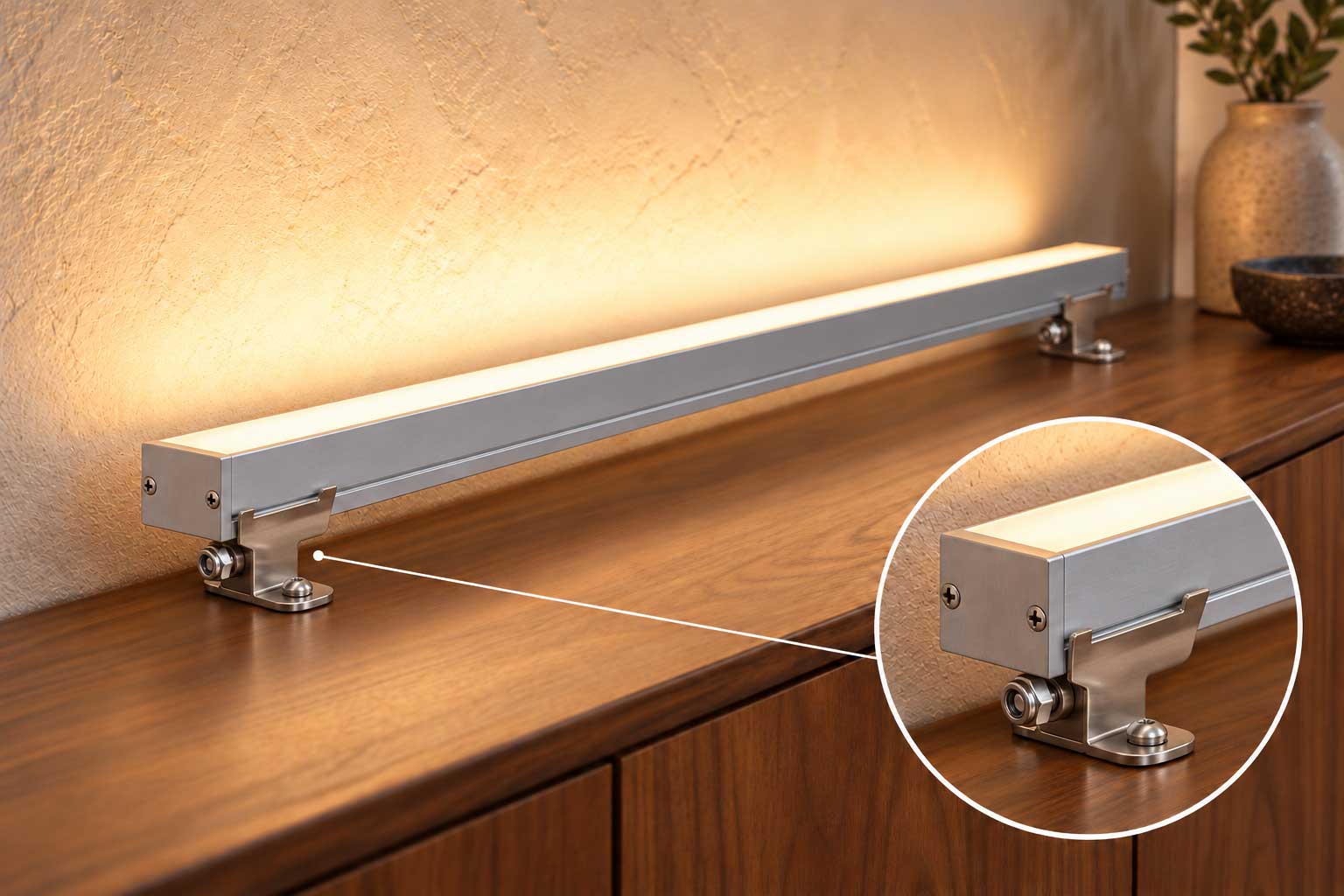 Illustrative channel installation above a walnut cabinet illuminating a textured wall